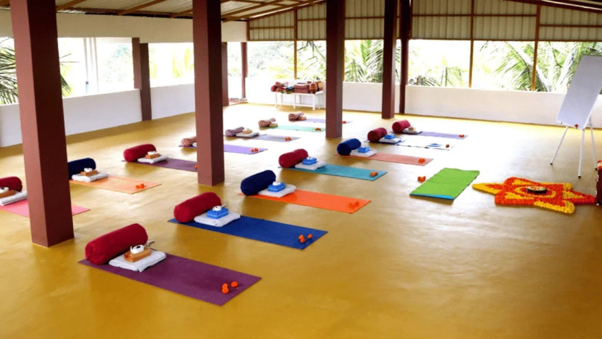 Yoga hall laid out with mats and bolsters before a class