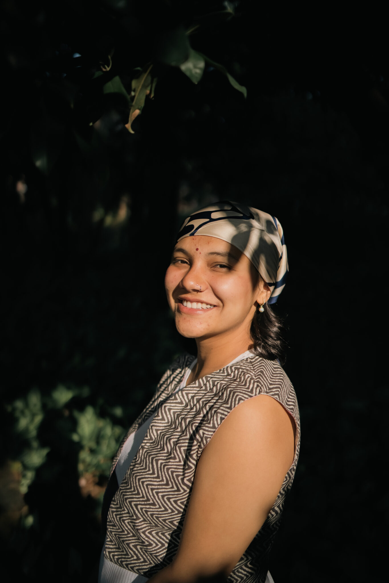 Parvati, yoga teacher at Yoga Nisarga, photographed against a dark background