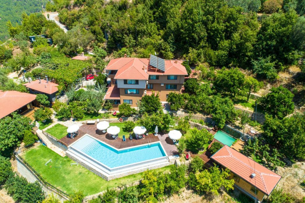 Aerial view of the retreat villa and swimming pool surrounded by trees