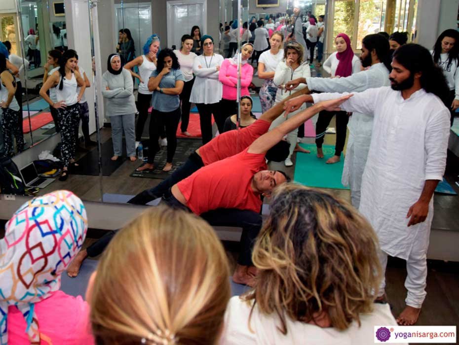 Teacher assisting students during a group class in a mirrored studio