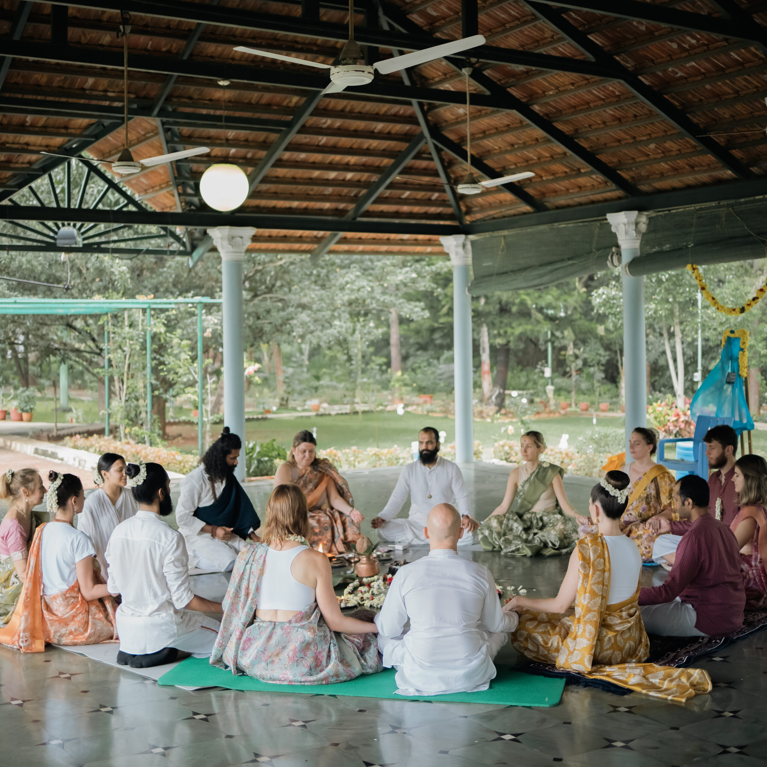Students seated in an open-air shala during a yoga philosophy session