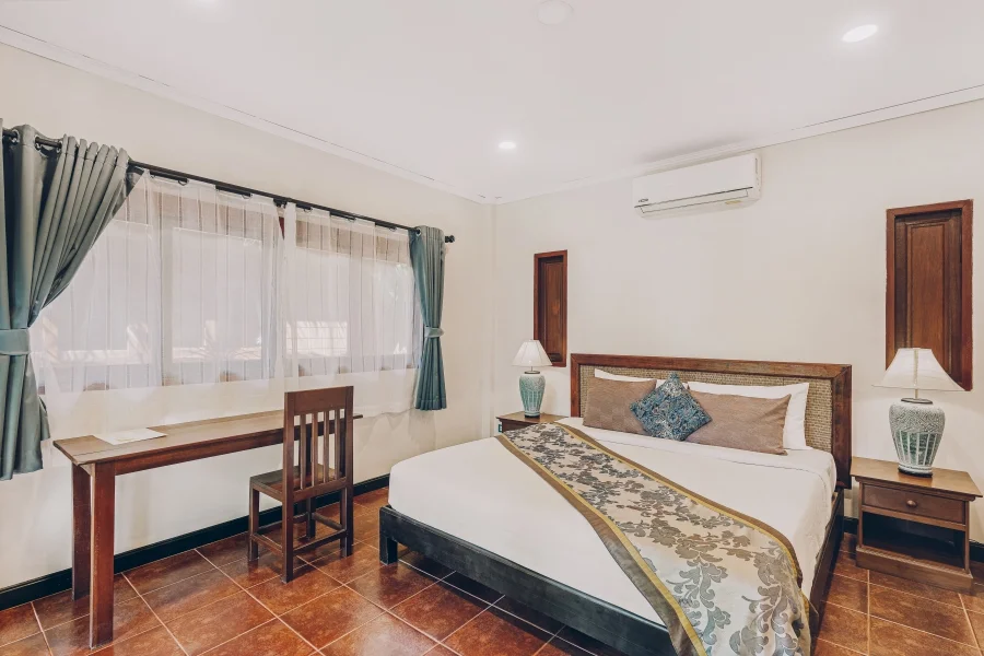 Superior room with a wood bed, teal curtains, and a small work desk by the window.