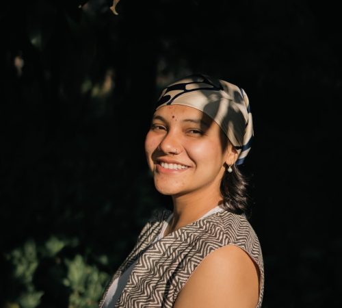 Parvati, yoga teacher at Yoga Nisarga, photographed against a dark background