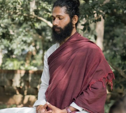 Swami Hari (Swami Chaittanya Hari), founder of Yoga Nisarga, seated in meditation outdoors