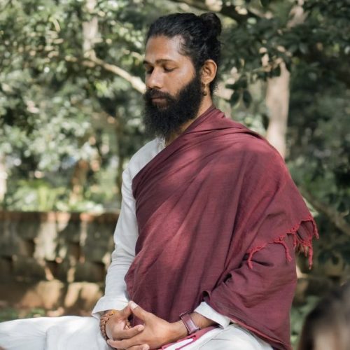 Swami Hari (Swami Chaittanya Hari), founder of Yoga Nisarga, seated in meditation outdoors